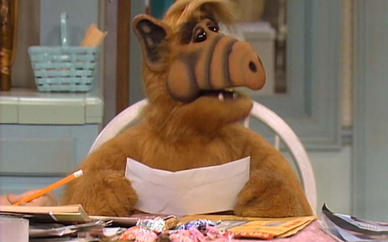 ALF, el extraterrestre peludo de la serie, sentado a la mesa del living de los Tanner