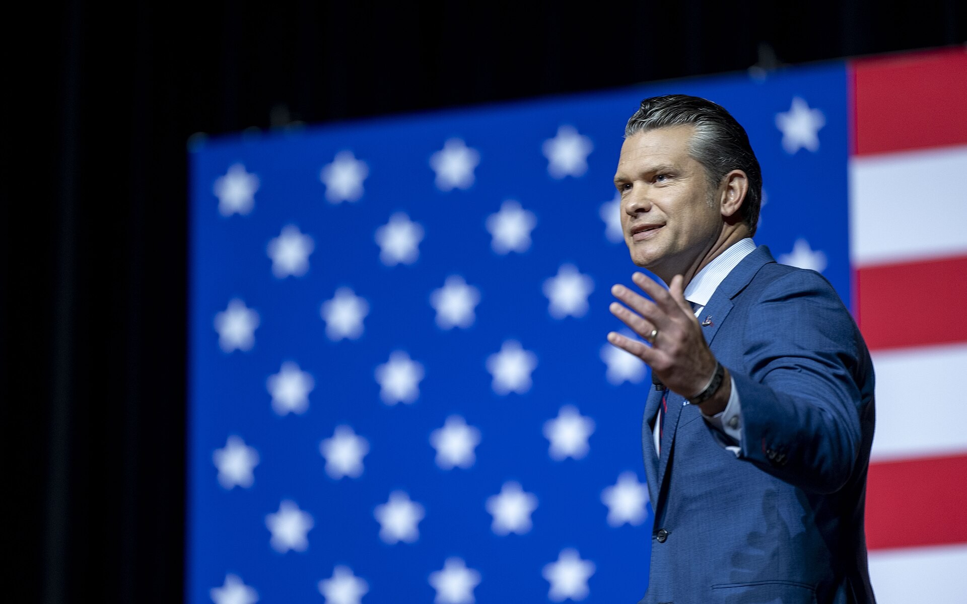 Pete Hegseth hablando frente a una bandera de Estados Unidos