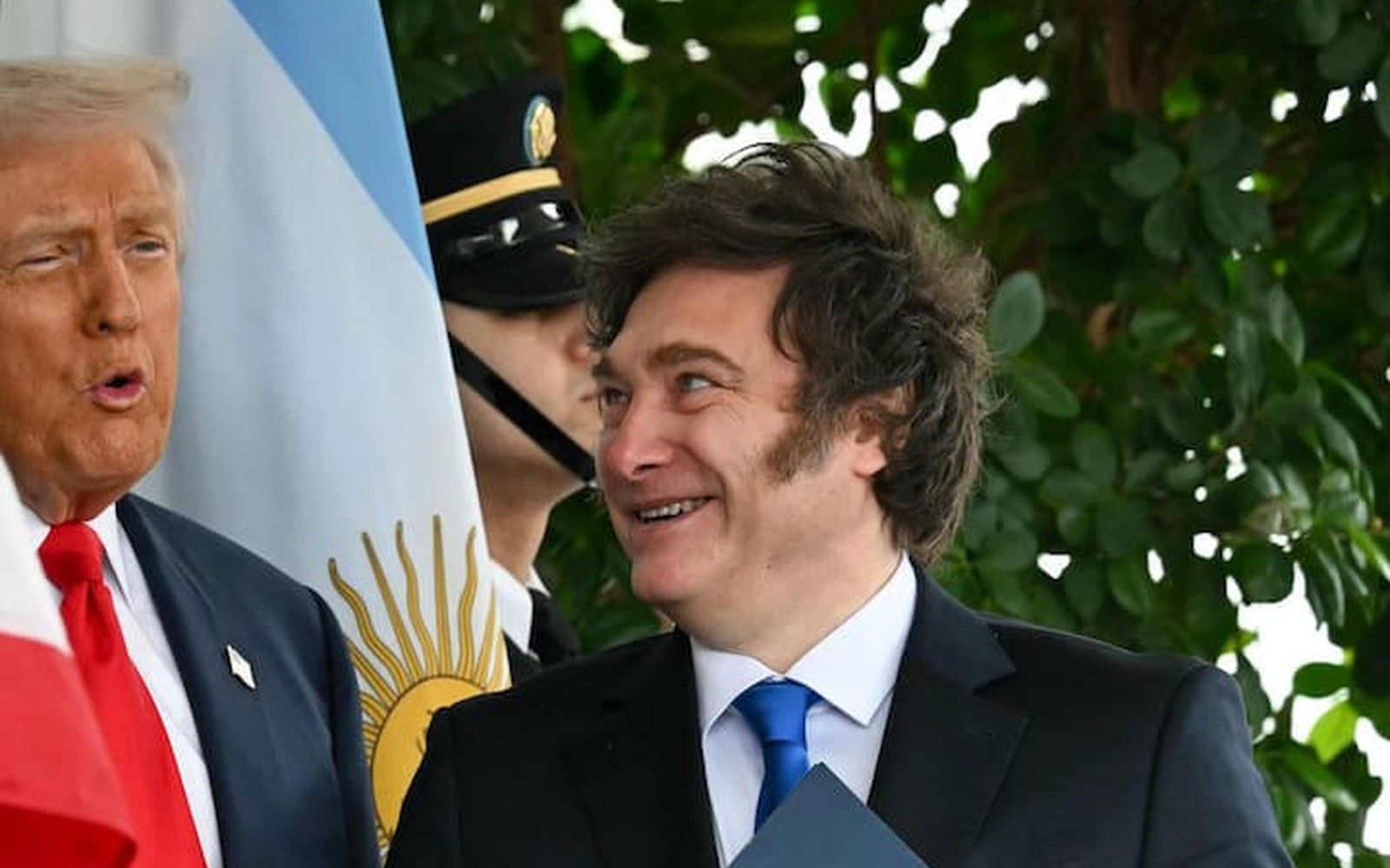 Javier Milei, de traje y corbata azul, con el pulgar arriba, al lado de Donald Trump