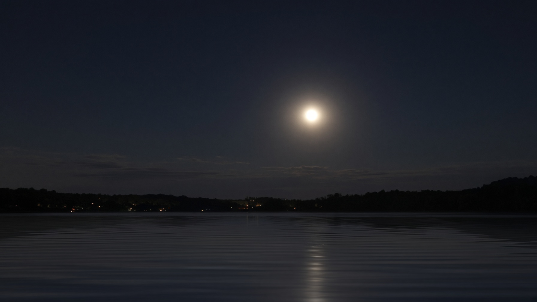 Punto luminoso sobre el agua, cielo nocturno