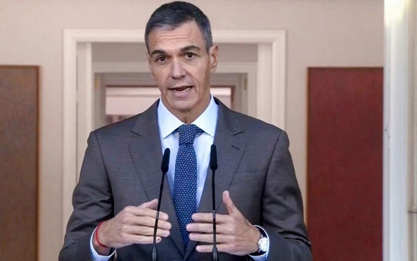 Pedro Sánchez, de traje y corbata roja, con la bandera de la Unión Europea detrás