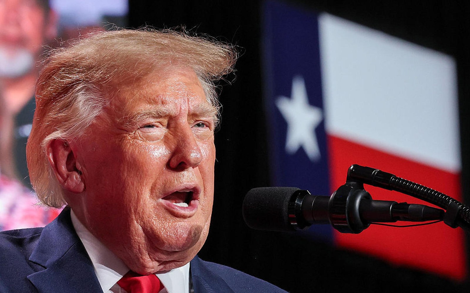 Donald Trump habla en un micrófono